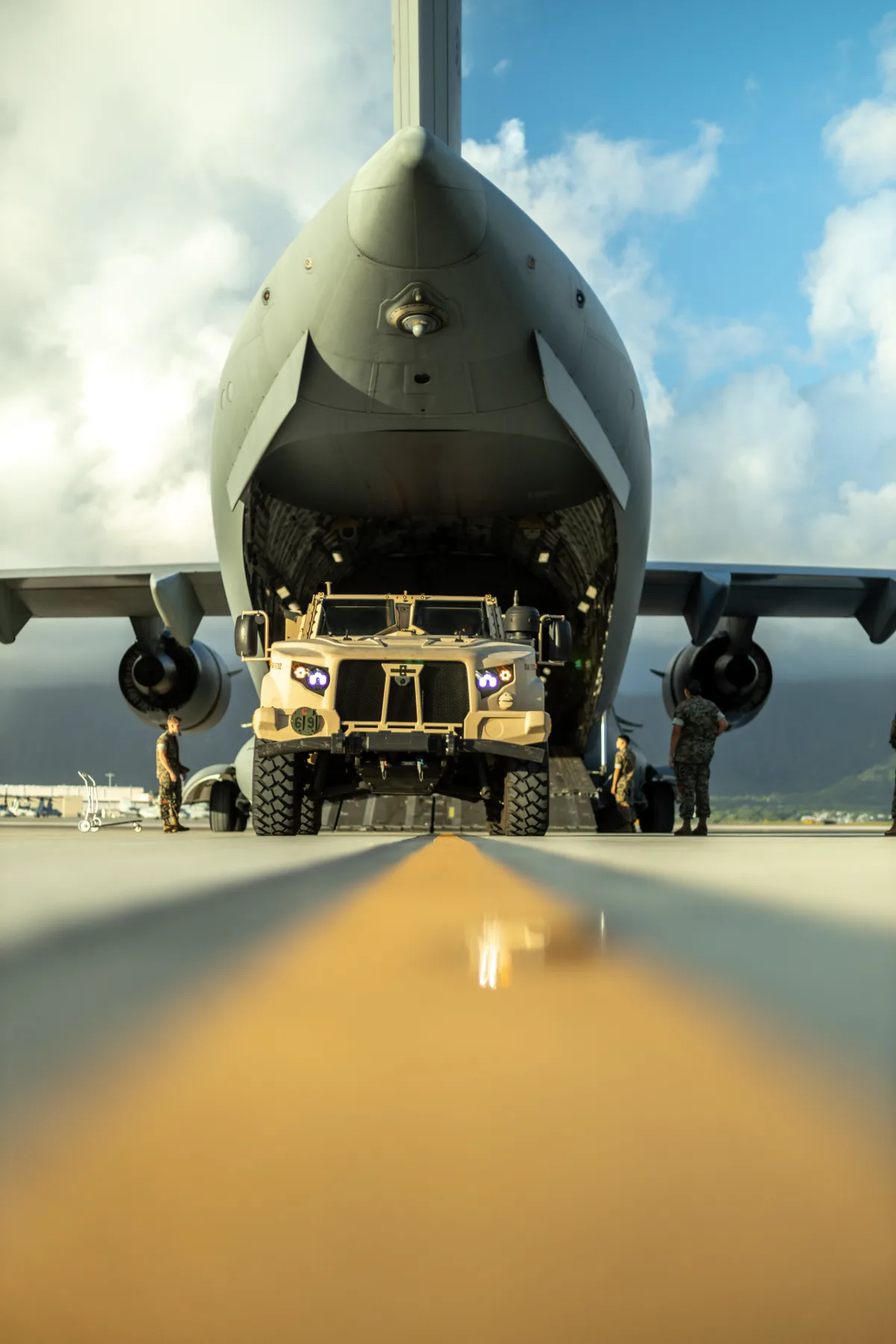 A vehicle being loaded through the nose ramp of a military transport aircraft.
